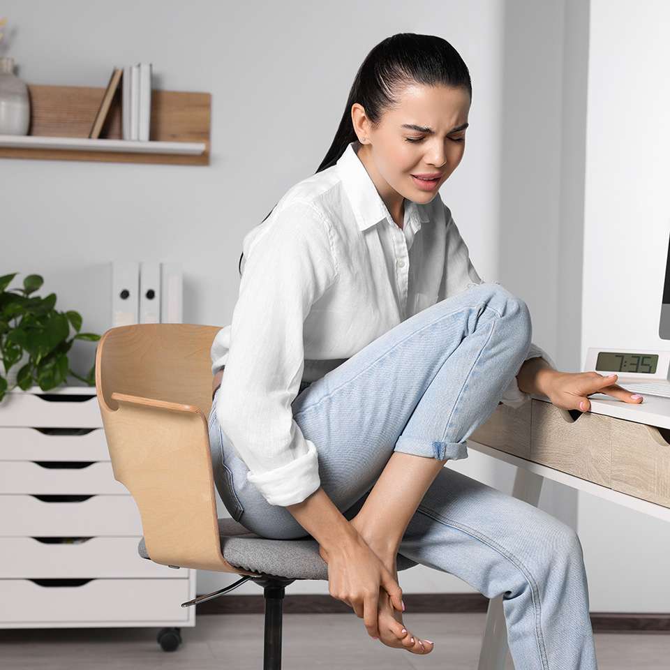 woman holding foot in pain